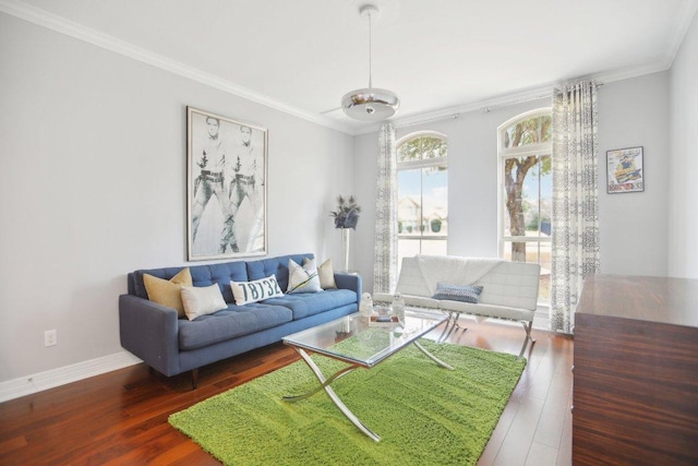 living area with baseboards, wood finished floors, and crown molding