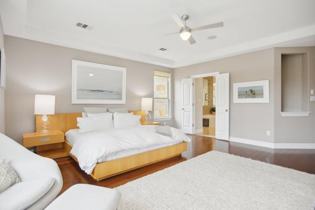 bedroom featuring baseboards, visible vents, ceiling fan, and wood finished floors