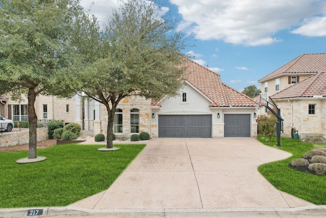 view of front facade with an attached garage, a tile roof, concrete driveway, stone siding, and a front lawn