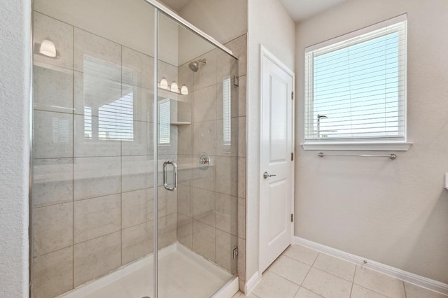 full bath featuring a shower stall, baseboards, and tile patterned floors