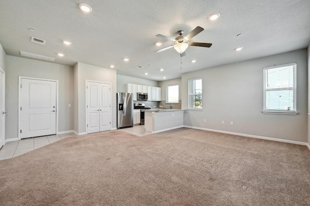 unfurnished living room featuring light carpet, a textured ceiling, visible vents, and recessed lighting