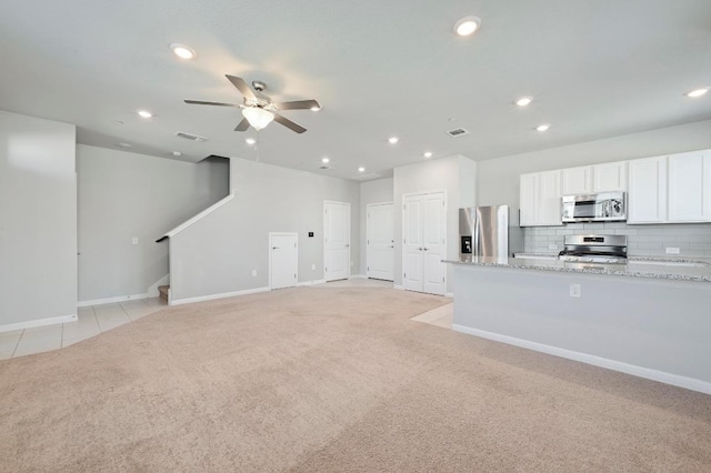 unfurnished living room featuring stairway, recessed lighting, visible vents, and light colored carpet