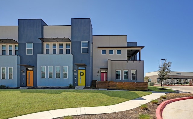 view of front facade with a front lawn, central AC unit, and stucco siding