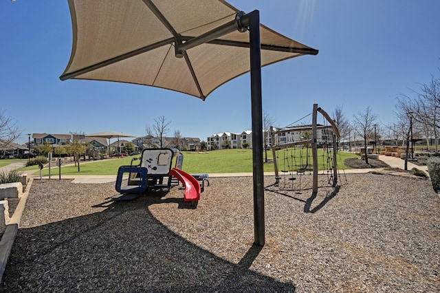 community play area featuring a lawn and a residential view