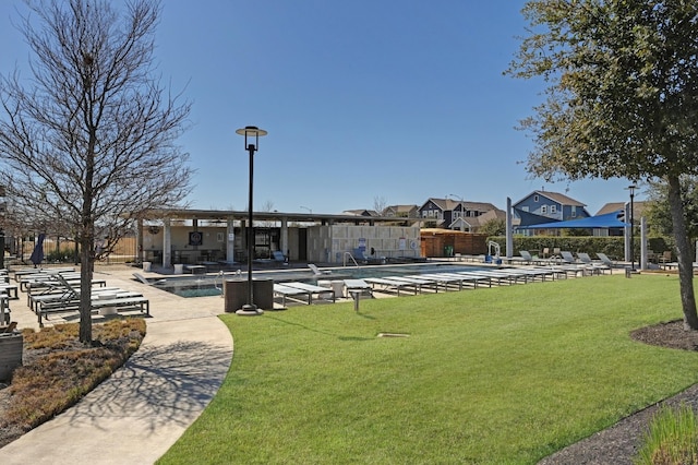 view of property's community featuring a patio, a lawn, a swimming pool, and a residential view