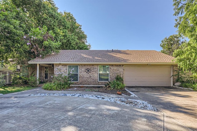 ranch-style house with a garage, concrete driveway, brick siding, and a shingled roof