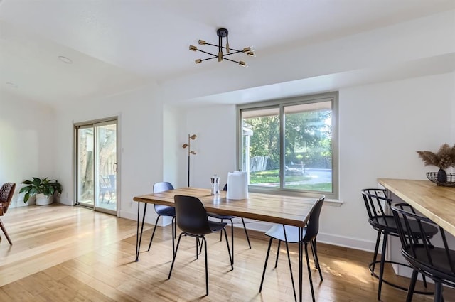 dining room with baseboards, a chandelier, and wood finished floors