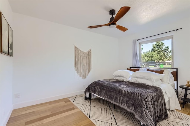 bedroom featuring light wood-type flooring, ceiling fan, and baseboards