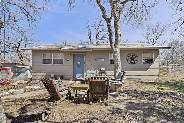 view of front of home with an outdoor fire pit and fence