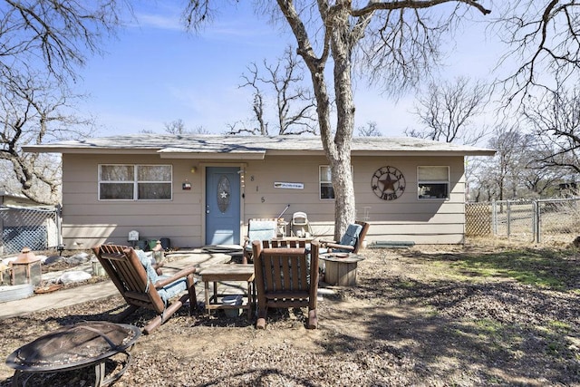 back of house featuring a fire pit and fence