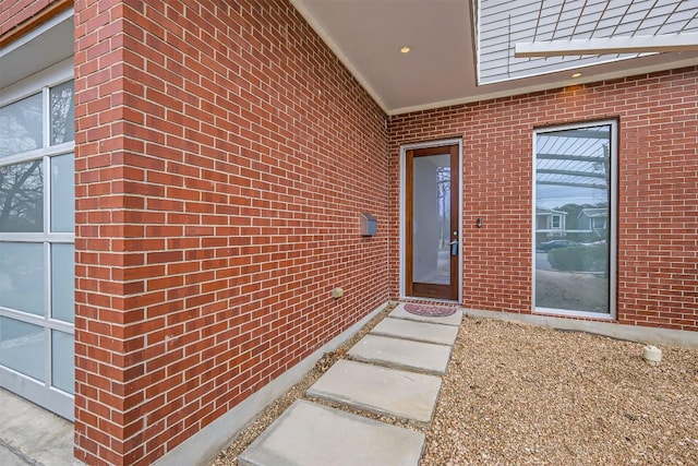 property entrance with a garage and brick siding