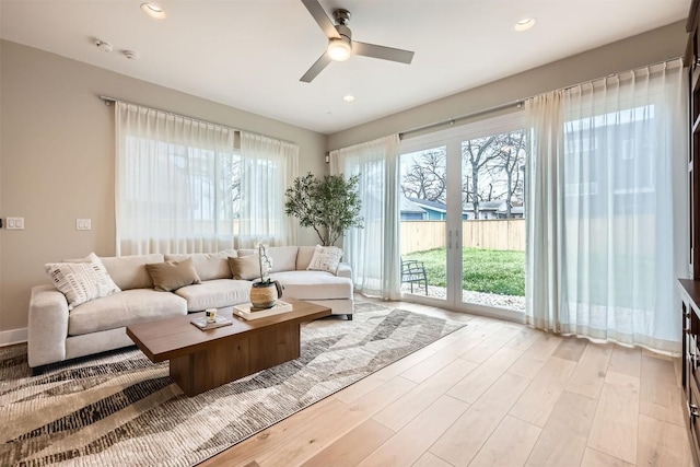 living room with a ceiling fan, light wood-type flooring, and recessed lighting