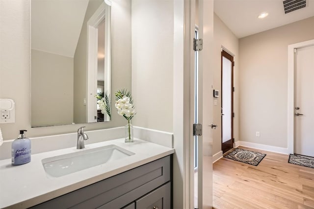 bathroom featuring recessed lighting, wood finished floors, vanity, visible vents, and baseboards