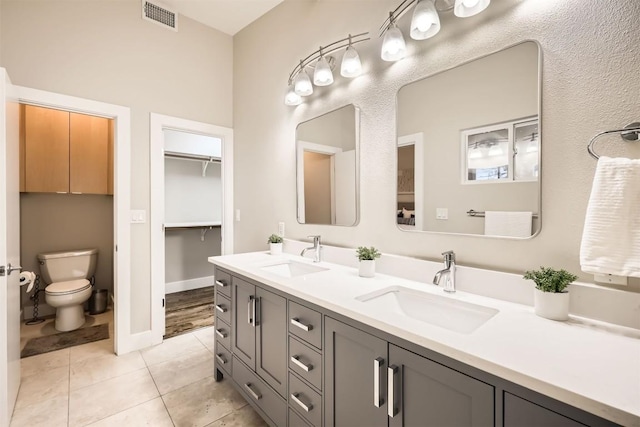 full bath with double vanity, a sink, visible vents, and tile patterned floors