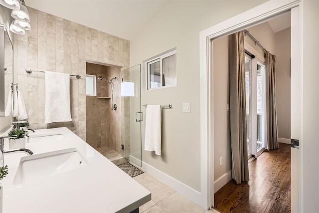 bathroom with a stall shower, a sink, and a wealth of natural light