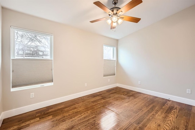 empty room featuring a ceiling fan, baseboards, and wood finished floors