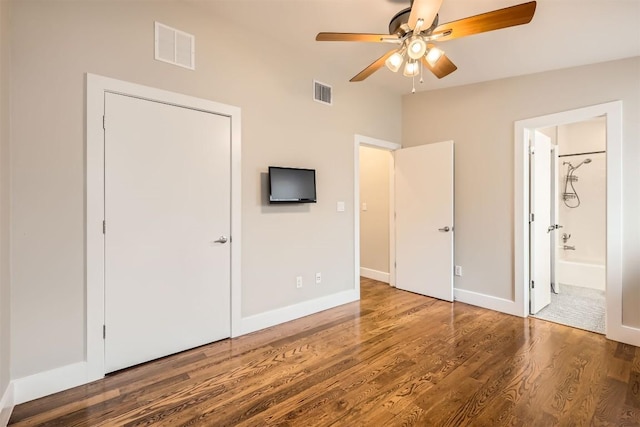 unfurnished bedroom with visible vents, ensuite bath, baseboards, and wood finished floors