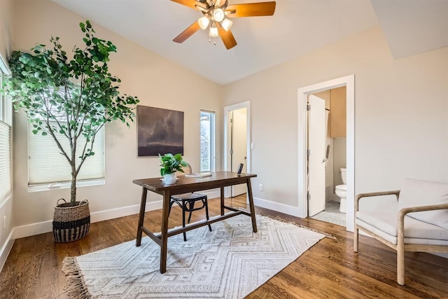 office featuring a ceiling fan, lofted ceiling, baseboards, and wood finished floors