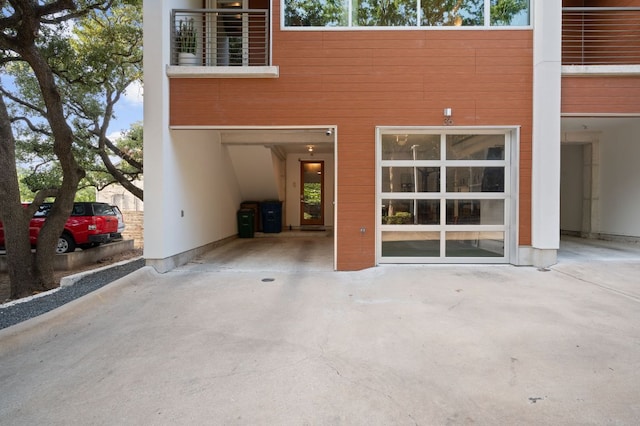 rear view of property with a garage and concrete driveway