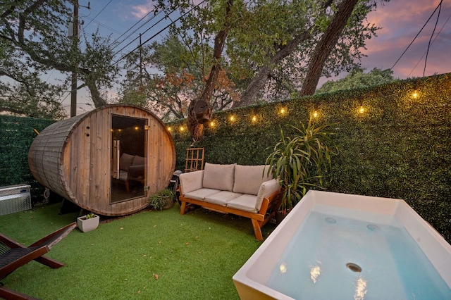 exterior space featuring a jacuzzi, an outdoor structure, and an outdoor hangout area