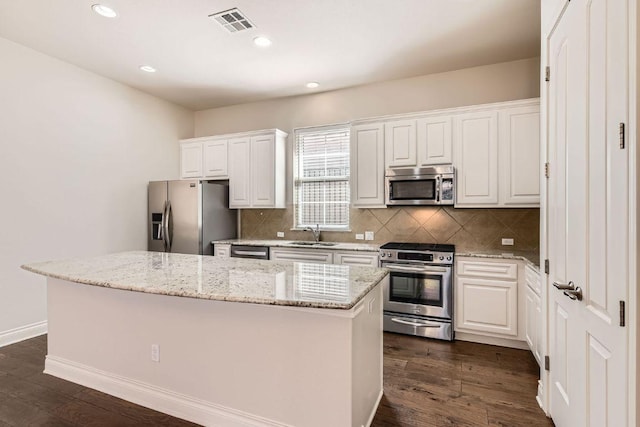 304 Belforte Ave, Austin, TX 78734 - kitchen featuring appliances with stainless steel finishes, a sink, a kitchen island, white cabinets, and recessed lighting