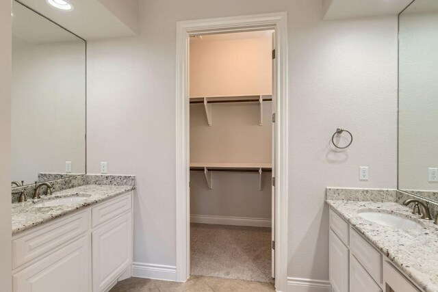 304 Belforte Ave, Austin, TX 78734 - full bathroom featuring two vanities, baseboards, a walk in closet, and tile patterned floors