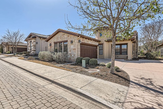 view of front facade with stone siding, a tile roof, driveway, and stucco siding