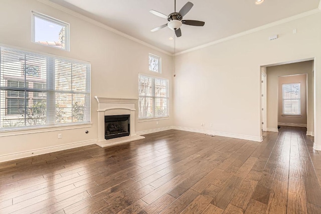 304 Belforte Ave, Austin, TX 78734 - unfurnished living room with a ceiling fan, plenty of natural light, a fireplace with raised hearth, dark wood-style flooring, and crown molding