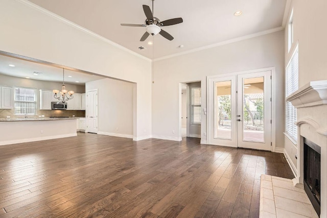 304 Belforte Ave, Austin, TX 78734 - unfurnished living room with a chandelier, a ceiling fan, a fireplace, dark wood-type flooring, and crown molding