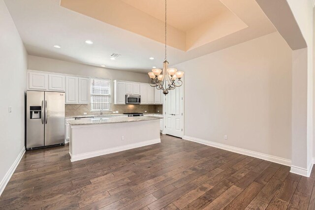 304 Belforte Ave, Austin, TX 78734 - kitchen featuring appliances with stainless steel finishes, a chandelier, a sink, a kitchen island, and white cabinets