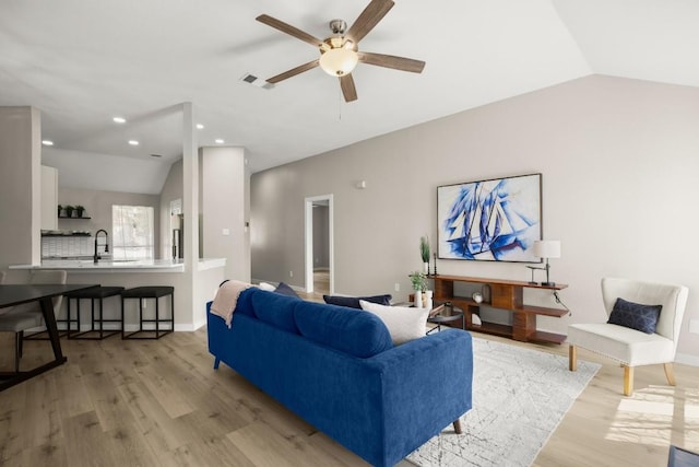 living area with lofted ceiling, light wood-type flooring, baseboards, and recessed lighting