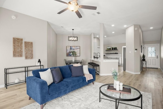 living room with light wood-type flooring, visible vents, and recessed lighting