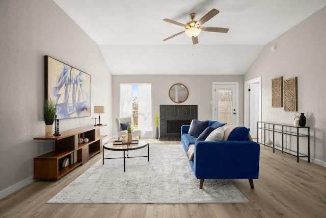 living area with lofted ceiling, wood finished floors, and baseboards