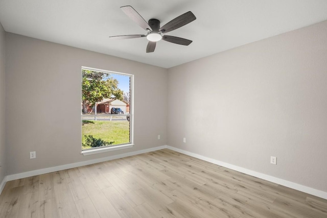 empty room with ceiling fan, baseboards, and wood finished floors