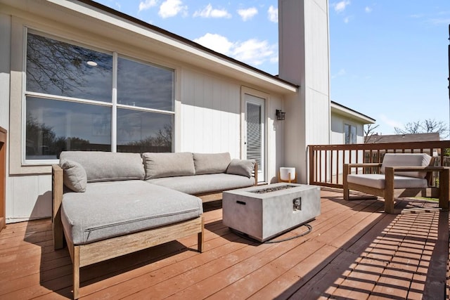 wooden terrace featuring an outdoor living space with a fire pit