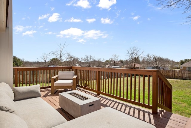 wooden deck featuring an outdoor fire pit and a yard