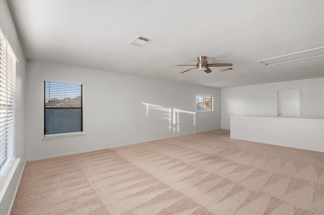 empty room with light carpet, visible vents, and a healthy amount of sunlight