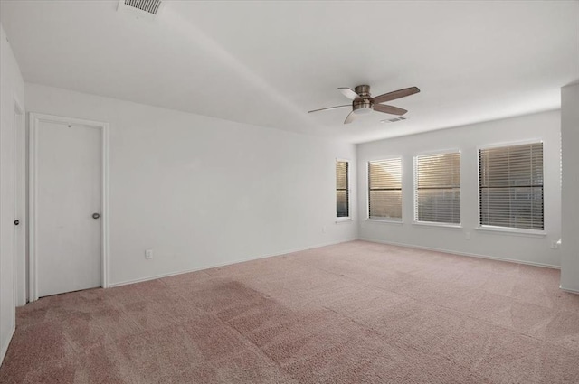 carpeted empty room featuring baseboards, visible vents, and a ceiling fan