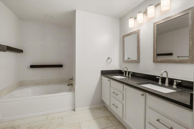 full bathroom with a garden tub, marble finish floor, double vanity, and a sink