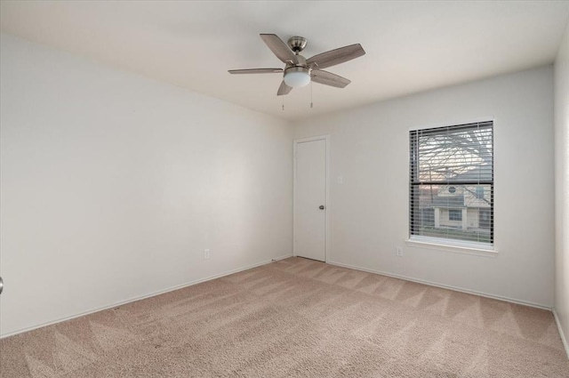 spare room featuring a ceiling fan and light colored carpet