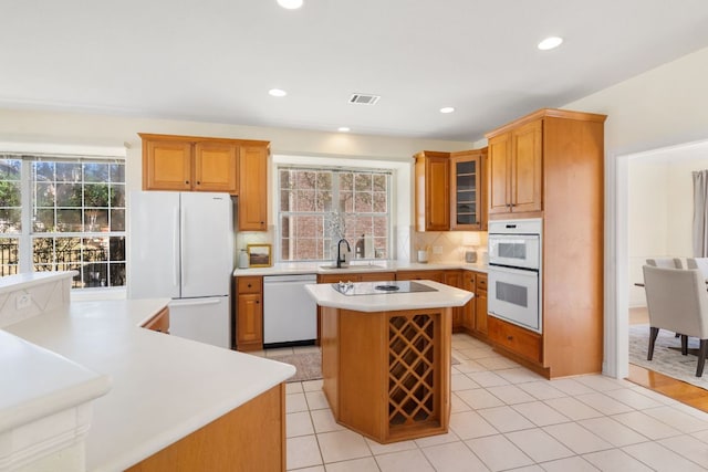 kitchen with plenty of natural light, white appliances, light countertops, and a kitchen island