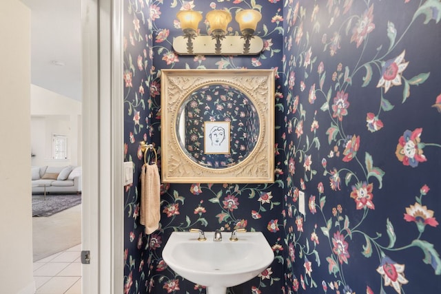 bathroom with vaulted ceiling, tile patterned floors, a sink, and wallpapered walls