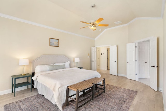 bedroom featuring light wood-type flooring, lofted ceiling, crown molding, and baseboards