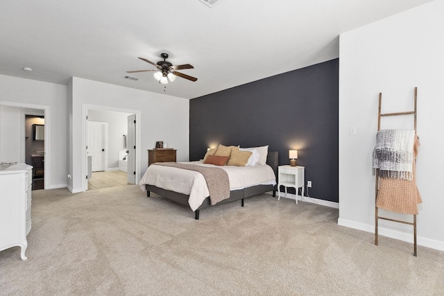 bedroom featuring light carpet, ensuite bath, visible vents, and baseboards