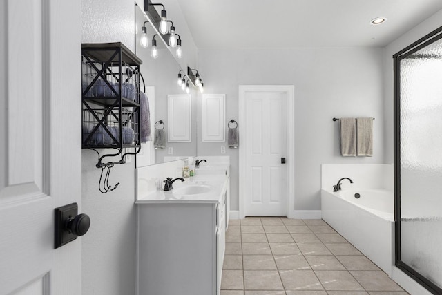 full bath with double vanity, baseboards, tile patterned floors, a garden tub, and a sink