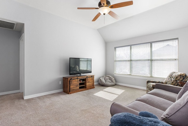 living area with light colored carpet, visible vents, a ceiling fan, vaulted ceiling, and baseboards