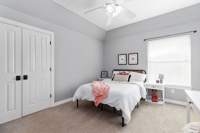 carpeted bedroom featuring lofted ceiling, a closet, ceiling fan, and baseboards