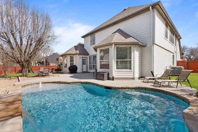 back of property featuring a shingled roof, a fenced in pool, a patio area, and fence