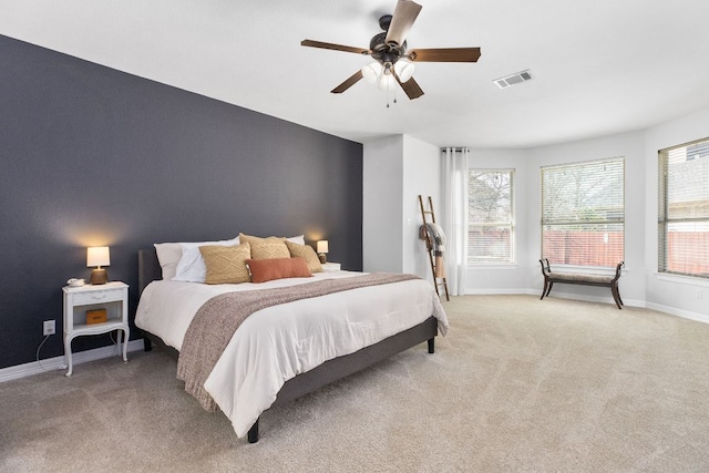 bedroom featuring light carpet, baseboards, visible vents, and a ceiling fan