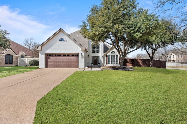 view of front of home featuring a garage, concrete driveway, a front lawn, and fence